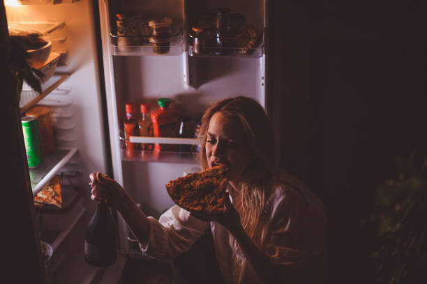 Jovem bebendo e comendo tarde da noite